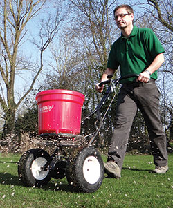 Lawn feed being spread on a lawn. Part of lawn care programme. Tim Hector